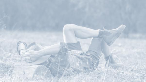 Mann liegt im Gras und ruht sich aus