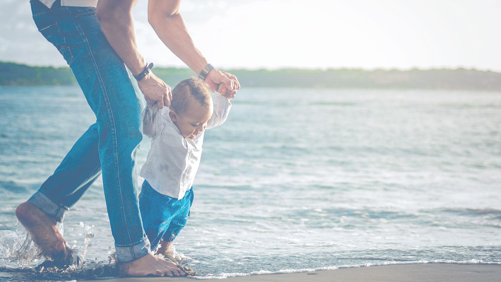 Junger Vater mit seinem Sohn am Strand