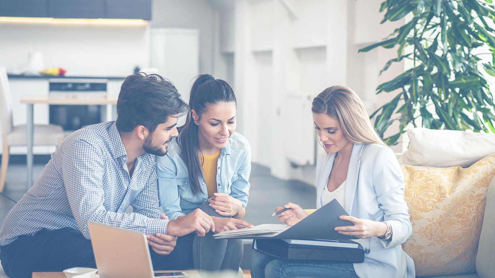 Finanzpartnerin zusammen mit jungem Paar bei der Beratung