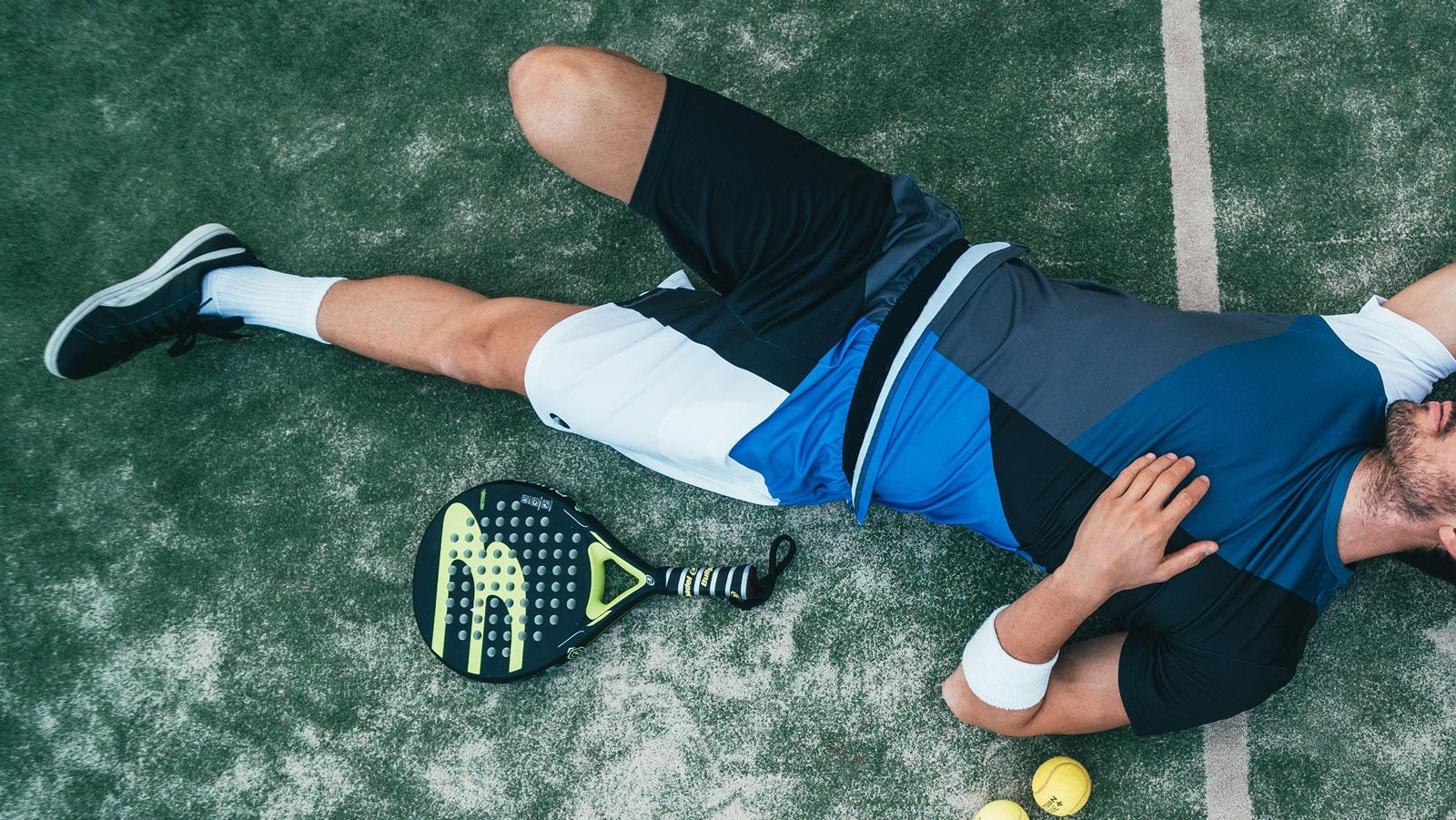 Junger Mann denkt beim Tennis über seine Gesundheit nach